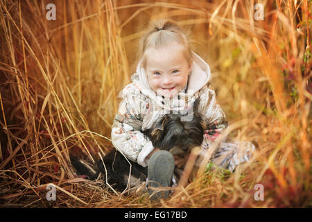 Belle fille avec le syndrome de hugs chiot Banque D'Images