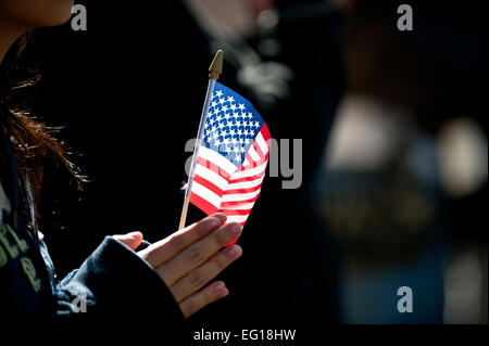 LAS VEGAS -- un spectateur tenir un drapeau américain tout en se trouvaient à bord de l'US Air Force sur la garde d'honneur de mars et effectuer au cours de la Journée des anciens combattants de Las Vegas le 11 novembre 2010 Défilé. Airman de la Nellis Air Force Base, Nevada, Airman Leadership School a également participé à la parade. U.S. Air Force photo / Tech. Le Sgt. Michael R. HolzworthReleased Banque D'Images