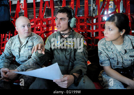 Les cadres supérieurs de l'US Air Force Airman Joseph Doria, un 36e Escadron de transport aérien de l'arrimeur Yokota Air Base, Japon, parle avec l'American Forces Network radiodiffuseur Tokyo aviateur Senior Tchad Usher et 36e radiodiffuseur des affaires publiques de l'Escadre d'un membre de la 1re classe Mariko Frazee le 14 décembre sur la route d'airdrop lors de l'Opération Goutte de Noël 2010. Aviateurs de la 36e Escadre à Andersen Air Force Base, Guam et le 36e Escadron de transport aérien se réunissent chaque année dans le cadre d'un exercice d'entraînement d'abandonner des milliers de livres de dons de matériel sur l'îles micronésiennes. Cette année, plus de 20 000 livres de fournitures, Banque D'Images