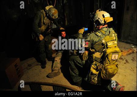 Les agents de la Drug Enforcement Administration, photographier un "combattant ennemi" capturés à des fins d'identification de drogue lors d'un raid sur une valeur élevée de la cible, le Stennis Space Center, au Mississippi, à l'appui d'Emerald Warrior, le 3 mars 2011. Emerald Warrior est un commandement des opérations spéciales américaines, parrainé par l'exercice multiservice conçu pour tirer parti des enseignements tirés des opérations Iraqi Freedom et Enduring Freedom à fournir des forces entraînées et prêtes pour les commandants de combat US Air Force photo par Jonathan SSgt LoveladyReleased Banque D'Images