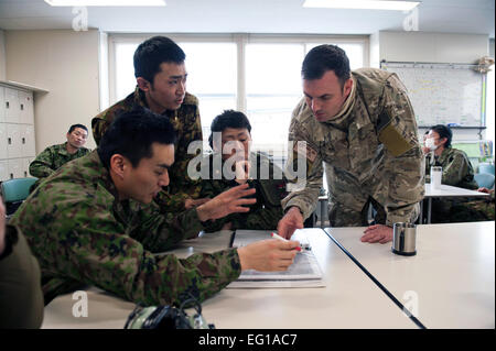 U.S. Air Force Le Major John Traxler, le 320th Special Tactics Squadron commandant, et les membres de l'Autodéfense de masse du Japon de discuter de la possibilité d'utiliser comme combustible Yamagata zone de rassemblement le 13 mars 2011. La zone peut être utilisé pour faire le plein avec l'aide d'aéronefs séisme et tsunami du Japon en matière de rétablissement. Le s.. Samuel Morse Banque D'Images