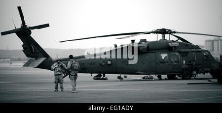 YOKOTA AIR BASE, Japon -- Deux membres de l'équipe mène de la 320th Special Tactics Squadron de Kadena Air Base, du Japon, de discuter de la prochaine mission avant de monter à bord d'un HH-60G Pave Hawk ici le 15 mars. La 320ème STS a lutter contre les contrôleurs, pararescuemen et d'opérations spéciales les équipes de météo d'aller n'importe où et de configurer les emplacements avancés d'opérations et impromptu de pistes. Le s.. Samuel Morse Banque D'Images