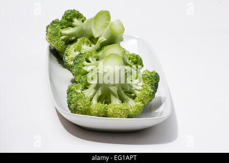 Fresh Brocoli (Brassica oleracea italica) groupe dans une assiette blanche sur fond blanc Banque D'Images