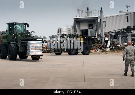 Les membres du 353e groupe d'opérations spéciales chariots élévateurs de palettes de transport de l'eau douce, pour être chargés sur le Japon d'Autodéfense de masse des camions à l'Aéroport de Sendai, Japon, le 20 mars. Le 320e Escadron tactique spéciale gère l'aérodrome avec l'aide de la 353SOG, marines, et d'autres organismes JGSDF japonais. L'Aéroport de Sendai est devenu un centre de contrôle principal pour que l'aide humanitaire aux personnes touchées par le séisme et le tsunami du 11 mars. Le s.. Samuel Morse Banque D'Images