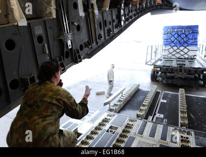 Royal Australian Air Force l'avion de tête Femme Robyn Lamont, mouvement de l'air technicien, l'aide humanitaire sur les maréchaux d'un C-17 Globemaster III le 21 mars. Avec l'aide de la RAAF, aviateurs Yokota 16 palettes livraison d'aide humanitaire à Sendai, Japon, dans le cadre de l'opération Tomodachi. L'opération Tomodachi est une mission de secours d'aider ceux qui sont touchés par les ravages causés par le récent tremblement de terre et le tsunami du 11 mars. Airman Senior Michael J. Veloz Banque D'Images