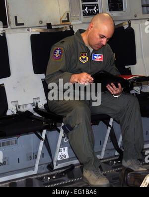 ALTUS AIR FORCE BASE, en Oklahoma -- Le Capitaine Jeremy J. Farlaino, 97e Escadron de formation de chef de la formation, de l'aile C-17 lit les plans de vol à bord d'un C-17 Globemaster III le 22 mars, avant de partir à l'appui de l'opération Odyssey Dawn. Le capitaine Farlaino est le commandant d'aéronef au cours de cette mission. Navigant de première classe Kenneth W. Norman/ 97e parution des affaires publiques de l'Escadre de la mobilité aérienne. Banque D'Images