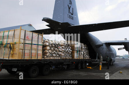 Un U.S. Air Force C-130 Hercules cargo) affecté à la 36e Escadron de transport aérien à Yokota Air Base, Japon, prépare pour le transport des approvisionnements de secours humanitaire de Chitose Air Base, Japon, à Matsushima, Japon, le 23 mars 2011. Les six palettes contiennent 15 000 livres d'eau, du riz et des couvertures. Le s.. Robin Stanchak Banque D'Images