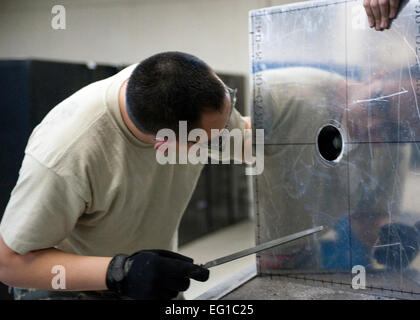 YOKOTA AIR BASE, Japon - Senior Airman Thompson Kongmany, 374e Escadron de maintenance technicien des métaux, examine un trou sur une feuille de métal ici le 28 mars 2011. Yokota de la maintenance a construit un support qui sera utilisé pour aider à recueillir des données à la centrale nucléaire de Fukushima. À l'appui des efforts de secours en cas de catastrophe, l'entretien de structures d'aéronefs Yokota aviateurs ont utilisé leurs compétences en conception et fabrication des moyens uniques et innovantes. Navigant de première classe Andrea Salazar Banque D'Images