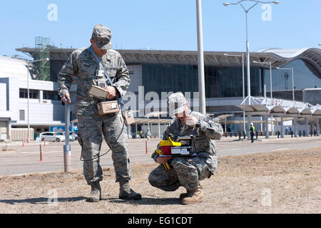 L'Aéroport de Sendai, Japon -- Le s.. Kevin Rivera et capitaine supérieur gauche Sgt. Dean Kim droite, tous deux de l'Armée de l'air l'équipe d'évaluation des rayonnements, vérifier le sol par un détecteur à l'iodure de sodium, de l'Aéroport de Sendai, 05 avril 2011. AFRAT L'analyse radiologique de l'air, l'eau, du sol et de l'expertise technique en physiologiques, de détection et de suivi de l'enquête. Yasuo Osakabe Banque D'Images