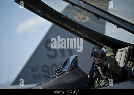 Le capitaine de l'US Air Force Jeremy Nolting, un pilote de la 79e Escadron de chasse, Shaw Air Force Base, S.C., met son casque dans le cockpit d'un F-16 Fighting Falcon avant de partir en mission d'entraînement à Nellis Air Force Base, Nevada, au cours de l'effort du drapeau vert à l'Ouest 11-6, avril 20, 2011. Drapeau vert à l'Ouest se reproduit la guerre irrégulière conditions actuellement trouvés dans le sud-ouest de l'Asie. Les équipages, travailler en étroite collaboration avec l'Armée de l'air de la finale de l'attaque aérienne. Les pilotes s'entraînent pour une des missions telles que l'appui aérien rapproché et la reconnaissance aérienne. Banque D'Images