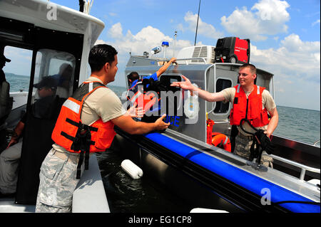 Les cadres supérieurs de l'US Air Force Airmen Joel Rodrigues et la Jordanie McDonald, à la fois 6e Escadron de patrouille maritime des Forces de sécurité d'aviateurs, passer un câble de remorquage entre bateaux sur la baie de Tampa, à Tampa, Floride, 10 juin 2011. Les aviateurs ont été les mains sur la formation au cours de la National Association of State Boating Law Administrators Voile Activités et programme de formation. Airman Basic David Tracy Banque D'Images