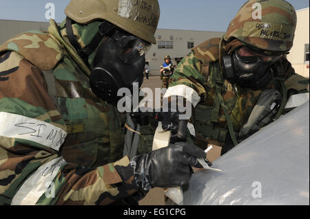 Les cadres supérieurs de l'US Air Force Airman David Washington,à gauche, et d'un membre de la 1re classe Eric Jones, tous deux du 35e Escadron de génie civil, porter des équipements de protection individuelle pour vérifier la contamination à la suite d'une attaque simulée lors d'un exercice d'entraînement à Misawa Air Base, Japon, le 20 juin 2011. En tant que membres d'une équipe de reconnaissance attaque post, les aviateurs sont responsables d'un certain nombre de situations pré- et post-attaque les actions visant à protéger les installations, le matériel et le personnel. Le s.. Avril Quintanilla Banque D'Images