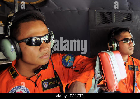 Deux pilotes de l'armée de l'air indonésienne observer un équipage avec le 36e Escadron de transport aérien à partir de Yokota Air Base, le Japon, se préparer à une mission de largage, le 21 juin 2011, au cours de l'effort à faire face à l'ouest à 11 Halim Air Base, l'Indonésie. Au cours de l'exercice, d'aviateurs, observer et échanger des tactiques, techniques et procédures pour renforcer le partenariat entre les États-Unis et les forces de l'air indonésienne. Le Capitaine Raymond Geoffroy Banque D'Images