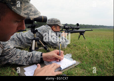 Le sergent de l'US Air Force. Crochet spot aide Carl une cible pour l'Aviateur Senior Timothy Collar puisqu'il s'apprête à congédier un fusil M-24, 7 juillet 2011, à Camp Robinson, Ark., au cours advanced marksman désigné formation en vue de la mobilité aérienne 2011 Rodeo. Hook et le collier sont des formateurs affectés à la 19e Escadron des Forces de sécurité à la base aérienne de Little Rock, Ark. Navigant de première classe Rusty Frank Banque D'Images