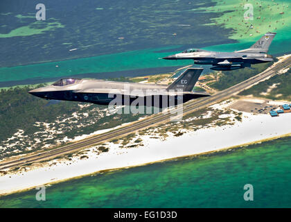 Le ministère de la défense d'abord de l'U.S. Air Force F-35 Lightning II JSF (Joint strike fighter aircraft monte sur Destin, en Floride, avec une armée de l'air F-16 Fighting Falcon avions avant l'atterrissage à sa nouvelle maison sur la base aérienne d'Eglin, le 14 juillet 2011. Son pilote, le Lieutenant-colonel Eric Smith du 58e Escadron de chasse, est le premier qualifié de l'Armée de l'air pilote JSF. Le s.. Joely Santiago Banque D'Images