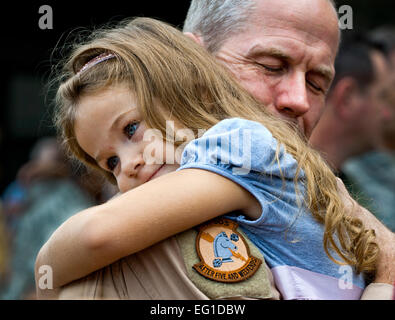 Le Lieutenant-colonel de l'US Air Force Thomas Frazier du 711e Escadron d'opérations spéciales du Canada reçoit un câlin de sa fille après son retour d'un déploiement en Asie du sud-ouest, le 7 août 2011. Plus de 25 aviateurs de la réserve de la Force aérienne ont été accueillis à la maison à un retour à la partie de la Duke, Floride Tech. Le Sgt. Samuel King Jr. Banque D'Images