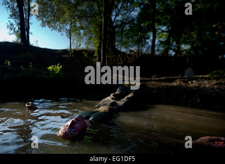 Un aviateur dips son corps dans l'eau pour nettoyer la saleté et de l'herbe au cours de l'endoctrinement de l'Armée de l'air Pararescuemen "Semaine d'Enfer", le 6 septembre 2011, à Lackland Air Force Base, Texas. Au cours de "semaine d'Enfer", aviateurs, simuler une mission mondiale qui pourraient impliquer l'air, le sol et l'eau de la survie. Aviateurs doivent compléter 62 semaines de formation en plus de la formation de base militaire pour devenir une Armée de l'air pararescueman. Le s.. Vernon Young Jr. Banque D'Images