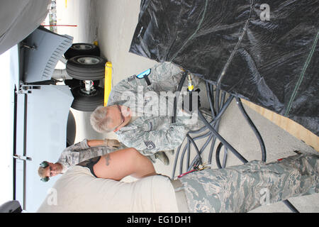 U.S. Air Force Tech. Le Sgt. Forte de la 191e Escadron de maintenance MXS permet de brancher un tuyau d'air pour un système de la vessie lors d'un exercice d'entraînement le 13 août 2011, à la base de la Garde nationale aérienne Selfridge (Michigan), la 191e MXS effectué un exercice où il simulait un U.S. Air Force KC-135 Stratotanker aerial refueling avion avait train avant endommagé, et une grue a été nécessaire pour déplacer l'appareil à un endroit sûr pour la réparation. Le système d'air a été utilisé pour remplir une série de vessies qui pourraient atténuer la queue de l'avion pendant que le nez de l'appareil a été levée par une grue. Tech. Le Sgt. Daniel Heaton Banque D'Images