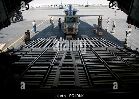 Les membres du 451e Escadron de préparation logistique expéditionnaire port aérien et vol 22e Escadron de transport aérien se préparent à charger un Marine américain F/A-18 Super Hornet de l'US Air Force sur un C-5 Galaxy cargo) sur l'aérodrome de Kandahar, Afghanistan, le 18 août 2011. Le Hornet a connu des dysfonctionnements qui pouvait le faire dévier et terre à l'aérodrome de Kandahar, en mars, et un soutien à l'opération Enduring Freedom. Carajal Senior Airman David Banque D'Images