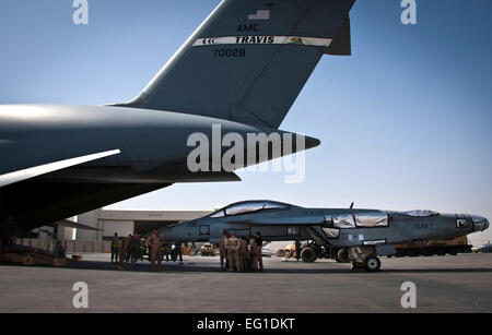 Aviateurs regarder par dessus un plan de chargement qui se prépare à charger un F/A-18 Super Hornet sur un C-5 Galaxy le 18 août 2011, à l'aérodrome de Kandahar, Afghanistan. C'était la première fois qu'un chasseur à réaction américain n'a été correctement chargé dans un avion-cargo pour le transport aux États-Unis les aviateurs sont affectés à la 451e Escadron de préparation logistique expéditionnaire à l'aérodrome de Kandahar et le 22e Escadron de transport aérien à Travis Air Force Base, Californie aviateur Senior David Carbajal Banque D'Images