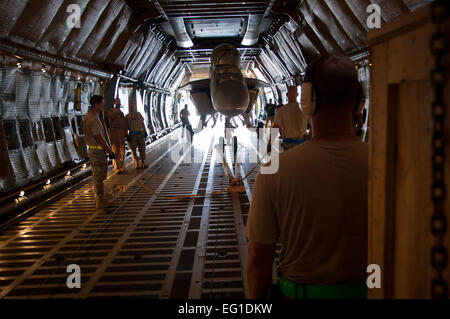 Les membres du 451e Escadron de préparation logistique expéditionnaire port aérien et vol 22e Escadron de transport aérien se préparent à charger un Marine américain F/A-18 Super Hornet de l'US Air Force sur un C-5 Galaxy cargo) sur l'aérodrome de Kandahar, Afghanistan, le 18 août 2011. C'était la première fois qu'un chasseur à réaction américain a été chargé dans un avion-cargo pour le transport vers les États-Unis. Après des mois de planification et de coordination, les leaders supérieurs à la Naval Air de la Marine et la Force aérienne des Forces canadiennes's Air Mobility Command a approuvé un plan pour transporter l'appareil à son accueil stat Banque D'Images