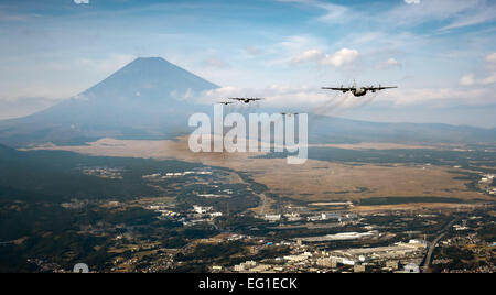 Formation d'un avion cargo C-130 Hercules volent ensemble comme ils sont exploités à Yokota Air Base, le Japon, d'une mission de formation près du Mont Fuji, le 2 novembre 2011. Les membres de l'équipage du 36e Escadron de transport aérien ont participé à ondes de samouraï, une journée d'entraînement à l'essai de la capacité de la mission de nombreux organismes tout au long de Yokota. Le Capitaine Raymond Geoffroy Banque D'Images