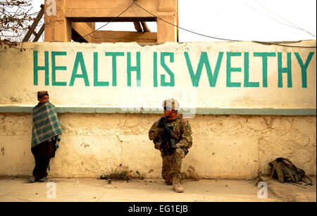 Les cadres supérieurs de l'US Air Force Airman David Cummings, une équipe provinciale de reconstruction Zabul medic, parle à un garçon afghan à l'extérieur de l'hôpital lors d'une patrouille à pied dans Shah Joy, Afghanistan, le 21 novembre 2011. Membres du PRT Zabul est allé à l'hôpital de procéder à un chef de mission. Cummings est déployé à partir de la Base aérienne de Lackland, à San Antonio, Texas. Fuentes-Contreras Grovert Senior Airman Banque D'Images