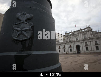 17 juin 2012 - Santiago, Chili, région métropolitaine/CL - Un écusson ou non gouvernementales chiliennes escudo '' doté d'un insigne comme médaillon avec un 5 branches et panache au-dessus peut être vu monté sur un mât au côté sud de la Plaza de la Constitucion et devant le palais présidentiel à Santiago. La Moneda ou ''La Moneda, '' conçu par l'architecte italien, JoquinToesca a été construit au cours des années de 1784 à 1805 et destiné à servir à l'origine comme une monnaie coloniale. Après l'indépendance du Chili de l'Espagne en 1818, et la présidence de Manuel Bulnes en 1845, la Moneda est devenue la mer Banque D'Images