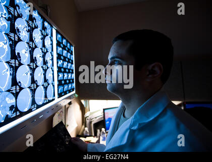 Le capitaine Le Dr Wesley Reynolds étudie un dossier patient computed tomography scan au Mike O'Callaghan Centre Médical fédéral 18 mars 2014, à Nellis Air Force Base, Nevada Mars est le mois de la sensibilisation à la lésion cérébrale. Selon l'Association canadienne des lésés cérébraux Nord, environ 75 pour cent des blessures traumatiques au cerveau sont les commotions cérébrales ou d'autres formes de TBIs doux. Reynolds est un 99e Escadron d'opérations médicales neurologue. Airman Senior Jason Couillard Banque D'Images