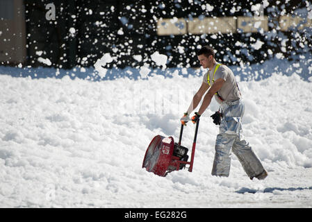 Airman Senior Allen Stoddard, 60e Escadron de génie civil, les courants d'une petite mer de mousse ignifuge qui a été involontairement dans un hangar pour avions à Travis Air Force Base, en Californie, le 24 septembre, 2013. La mousse non dangereux est semblable à du savon à vaisselle, qui a éventuellement dissous dans un liquide, qui a été aidé par des vents violents. La 60e Escadre de mobilité aérienne Les pompiers permettait de lutter contre la dispersion, à l'aide de ventilateurs puissants et couvrant les drains. Aucun peuple ou l'aéronef n'a été blessé dans l'incident. Ken Wright Banque D'Images