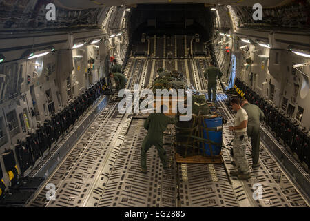 Les arrimeurs et de techniciens du 535e Escadron de transport aérien sûr et inspecter la cargaison sur un C-17 Globemaster III avant qu'un largage de at Joint Base Harbor-Hickam Pearl, Washington, 1er août 2014. La 535e offre des capacités de transport aérien et airdrop pour le théâtre du Pacifique. Le largage de matériel fait partie de la formation de routine de l'équipage et le personnel de la logistique. Le s.. Stephany Richards Banque D'Images