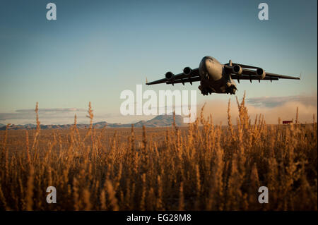 Un C-17 Globemaster III décolle d'un aérodrome dégradées le 6 décembre 2014, au cours de l'École d'armes de l'US Air Force l'entrée forcée de l'exercice 14B au Nevada Test et gamme de formation. JFEX exerce l'aptitude des participants à synchroniser les mouvements des aéronefs à partir de bases séparées géographiquement, de grandes formations de commande d'avions différents dans l'espace aérien à haut risque, et tactique de livrer et récupérer les forces de combat par l'intermédiaire de l'air chute et combattre les atterrissages sur une piste d'atterrissage non améliorées. Le C-17 est attribué à mars Air Reserve Base, Californie d'un membre de la 1re classe Joshua Kleinholz Banque D'Images