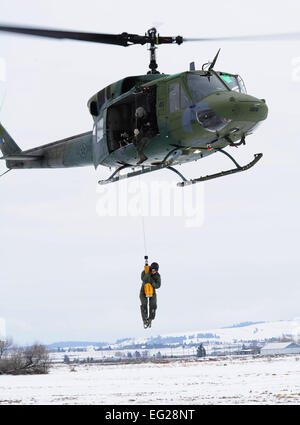 Un étudiant est hissé dans un UH-1N Iroquois lors d'un exercice d'entraînement à la survie, évasion, résistance et échapper à l'école le 25 janvier 2013, à Fairchild Air Force Base, dans l'état de l'école offre des cours pour préparer les étudiants pour réussir, parachute, terre survivre éventuellement être récupéré. Navigant de première classe Janelle Patiño Banque D'Images