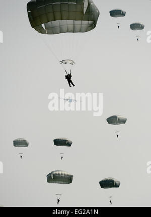 Les parachutistes de descendre lentement vers le sol comme un C-130 vole au loin dans la distance de saut International au cours de semaine à l'Alzey Zone d'atterrissage dans l'Allemagne. Plus de 300 cavaliers provenant de neuf pays différents a effectué 404 sauts en ligne et à l'électricité statique 132 altitude élevée, faible ouverture de sauts en trois jours. Un membre de la 1re classe Michael Stuart Banque D'Images