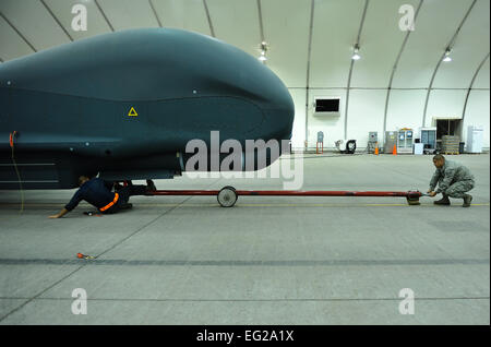 Airman Senior Blaine Aponte et le sergent. Juan Lopez enlever une barre de remorquage d'un RQ-4 Global Hawk avant d'effectuer des opérations de maintenance le 15 avril 2014, dans le sud-ouest de l'Asie. Le Global Hawk fournit des services de renseignement, de surveillance, de reconnaissance et de communication capacités au sud-ouest de l'Asie. Aponte et Lopez sont membres de la 380e Escadron de maintenance des aéronefs de la Force expéditionnaire du Canada. Tech. Le Sgt. Russ Scalf Banque D'Images