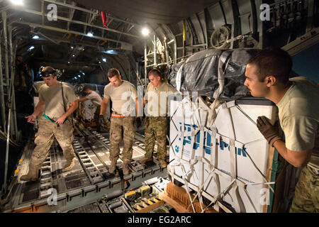 Les arrimeurs et les chefs d'équipage du 774e Escadron de transport aérien expéditionnaire de charger des cargaisons ensembles dans un C-130H Hercules destinés à une zone de largage à distance dans la province de Ghazni, en Afghanistan, le 6 octobre 2013 à l'aérodrome de Bagram, la province de Parwan, à l'Afghanistan. Photo de l'USAF/Master Sgt. Ben Bloker Banque D'Images