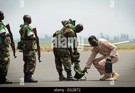 Les soldats rwandais à attendre en ligne à avoir leurs armes inspectées par le sergent. Curtis McWoodson raison, avant d'arriver sur un C-17 Globemaster III le 19 janvier 2014, à l'aéroport de Kigali, au Rwanda. Les forces américaines vont transporter 850 soldats rwandais et plus de 1 000 tonnes de matériel dans la République d'Afrique centrale pour faciliter les opérations de l'Union africaine et française contre les militants au cours de ces trois semaines de fonctionnement. McWoodson est membre de la 627ème escadron des Forces de sécurité Phoenix Raven, chargé de protéger le C-17 basée à Joint Base Lewis-McChord Air Force Base, Wa. Le s.. Ryan Crane Banque D'Images