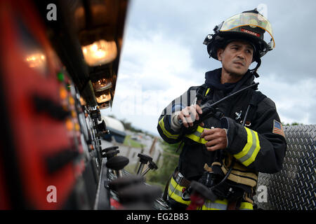 Keira Uehara, 18e Escadron de génie civil pompier, écoute la radio au sommet d'un camion d'incendie au cours de la simulation d'un accident de véhicules de matières dangereuses dans le cadre d'une mission axée sur l'exercice Kadena Air Base, le Japon, le 2 décembre 2014. L'exercice, les tests d'aviateurs sur leur capacité à survivre et fonctionner dans un environnement stressant, est programmé pour être exécuté à Décembre 4. Airman Senior Maeson L. Elleman Banque D'Images