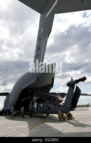 Les membres de la Garde nationale aérienne d'Alaska's 176th Wing charger un HH-60 Pave Hawk hélicoptère de recherche et de sauvetage sur un U.S. Air Force C-17 Globemaster III cargo) at Joint Base Elmendorf-Richardson, Alaska, pour une période de 120 jours de déploiement en Afghanistan le 28 mai 2012. L'hélicoptère est une partie d'un ensemble d'équipement et de l'équipage qui se déploie à l'appui de l'opération Enduring Freedom. Garde nationale photo par le Sgt. Shannon Oleson Banque D'Images