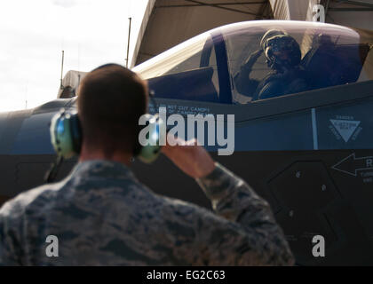 Le général Jay Silveria, U.S. Air Force, commandant du Centre de guerre rend hommage à son chef d'équipage navigant de première classe, Patterson, 33e Escadron de maintenance des aéronefs, comme il commence à circuler pour son dernier vol de qualification dans le F-35A Lightning II le 26 septembre 2014, à la base aérienne d'Eglin, en Floride Silveria est devenu le premier officier général au Ministère de la défense à se qualifier dans la cinquième génération de chasseurs. Il a complété sa formation avec dos-à-dos et les vols de ravitaillement chaud pit. Photo par Samuel King Jr. Banque D'Images