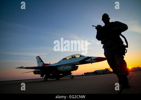 Le s.. Luis Rodriguez du New Jersey Air National Guard's 177e Escadron des Forces de sécurité effectue une marche tôt le matin-autour d'un F-16D Fighting Falcon de l'US Air Force Thunderbirds le 11 août 2014, à l'Atlantic City Air National Guard Base, au New Jersey. Les Thunderbirds sont le premier groupe de démonstration de vol AF et joué pour la ville de l'Atlantique sur la promenade "Thunder" meeting aérien le 13 août 2014. Tech. Le Sgt. Matt Hecht Banque D'Images