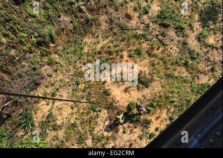 Une survie, évasion, résistance et d'évasion fiscale spécialiste aide la simulation d'un survivant dans l'estrope de sauvetage lors d'un de recherche et sauvetage de combat exercice du groupe de travail, le 15 octobre 2014, à Osan Air Base, République de Corée. L'exercice de deux semaines permet de former les équipages QR 33e pour des missions de combat et les prépare à des missions de sauvetage en territoire hostile. Le s.. Rachelle Coleman Banque D'Images