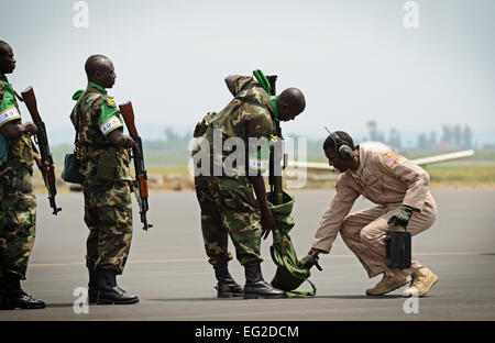 Les soldats rwandais à attendre en ligne à avoir leurs armes inspectées par le sergent. Curtis McWoodson raison, avant d'arriver sur un C-17 Globemaster III le 19 janvier 2014, à l'aéroport de Kigali, au Rwanda. Les forces américaines vont transporter 850 soldats rwandais et plus de 1 000 tonnes de matériel dans la République d'Afrique centrale pour faciliter les opérations de l'Union africaine et française contre les militants au cours de ces trois semaines de fonctionnement. McWoodson est membre de la 627ème escadron des Forces de sécurité Phoenix Raven, chargé de protéger le C-17 basée à Joint Base Lewis-McChord Air Force Base, dans l'État Le s.. Ryan Crane Banque D'Images