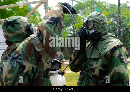 Le s.. Shaun Renn assiste un aviateur affecté à KoreaÕs sud 38e Groupe de chasse avec le masque de décontamination lavage station au cours de la simulation d'armes chimiques, biologiques, radiologiques et nucléaires de l'exercice d'attaque le 5 juin 2013, à Kunsan Air Base, la Corée du Sud. Les aviateurs de la Corée du Sud a eu l'occasion de chaque station au cours de l'exercice, leur donnant une chance d'apprendre de nouvelles tactiques, techniques et procédures. Renn est un compagnon de gestion d'urgence attribué à la 8e Escadron de génie civil. Jessica Haas Senior Airman Banque D'Images