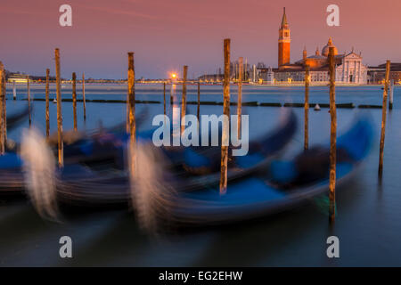 Les gondoles amarrées à l'île de San Giorgio Maggiore en arrière-plan au coucher du soleil, Venise, Vénétie, Italie