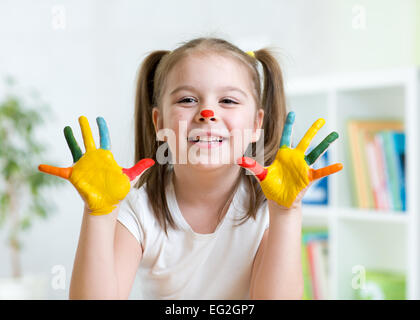 Cute kid enfant montrant ses mains peints dans des couleurs vives Banque D'Images