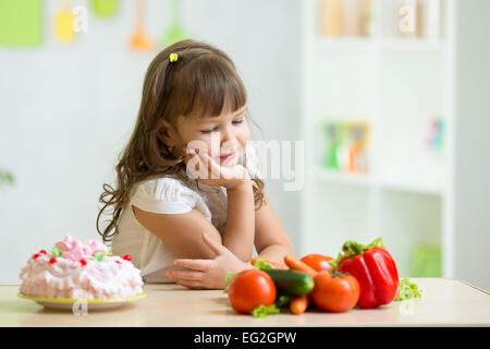 Enfant de choisir entre des légumes sains et savoureux bonbons Banque D'Images