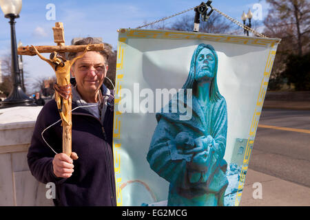 Man holding crucifix et Jésus bannière sur coin de rue - USA Banque D'Images