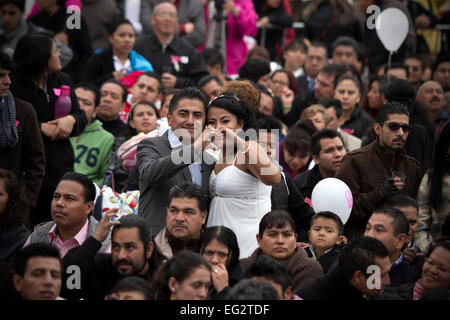 La ville de Mexico. Feb 14, 2015. Un couple pose lors d'un mariage collectif en place Zocalo à Mexico, capitale du Mexique, le 14 février 2015, le jour de la Saint-Valentin. © Alejandro Ayala/Xinhua/Alamy Live News Banque D'Images