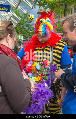 Jeune homme en costume de carnaval lumineux vend des fleurs, Hambourg, Allemagne, Europe Banque D'Images